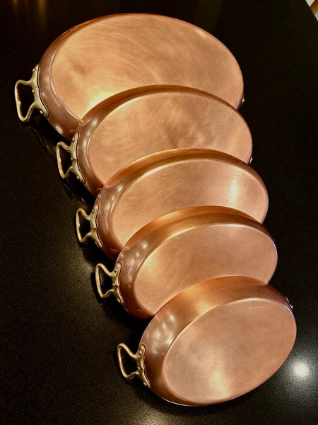 SET OF (5) EUROPEAN OVAL COPPER AU GRATIN / FISH PANS with brass handles. 24cm, 26cm, 30cm, 32cm and 38cm.